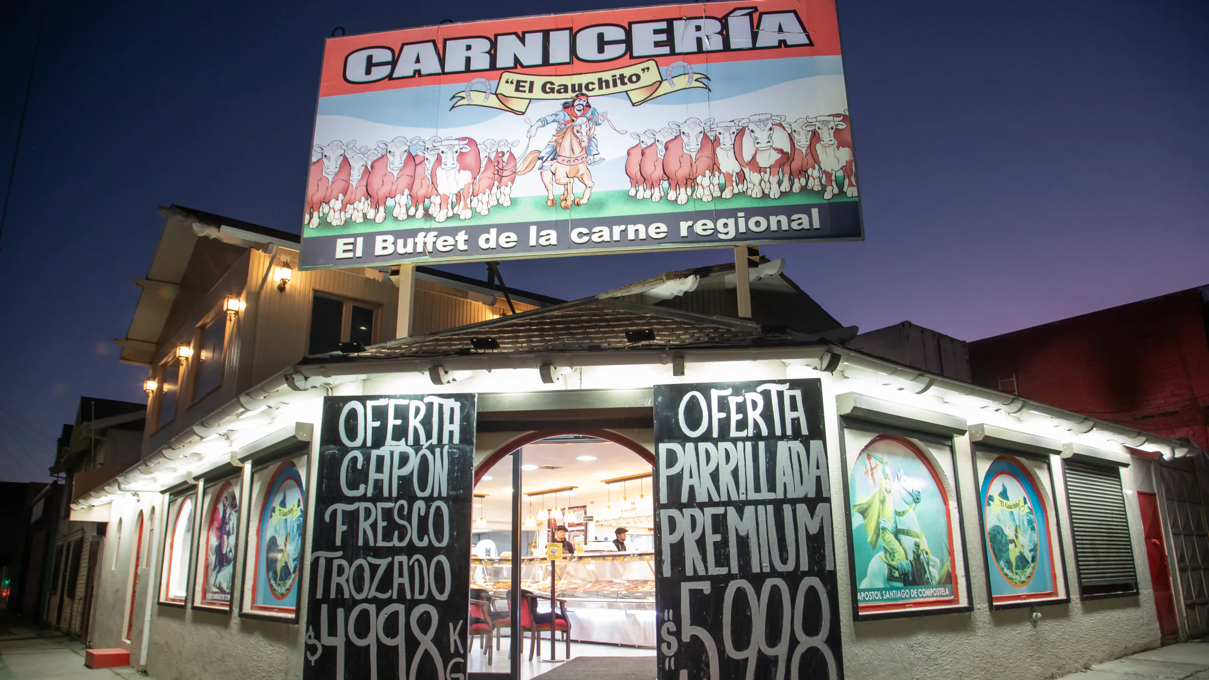 Fachada iluminada de Carnicería El Gauchito en Punta Arenas